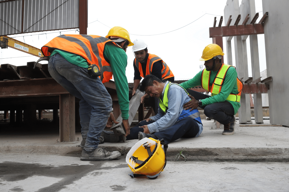Construction workers are engaged in a workplace emergency, collaborating on a construction site to address the situation.
