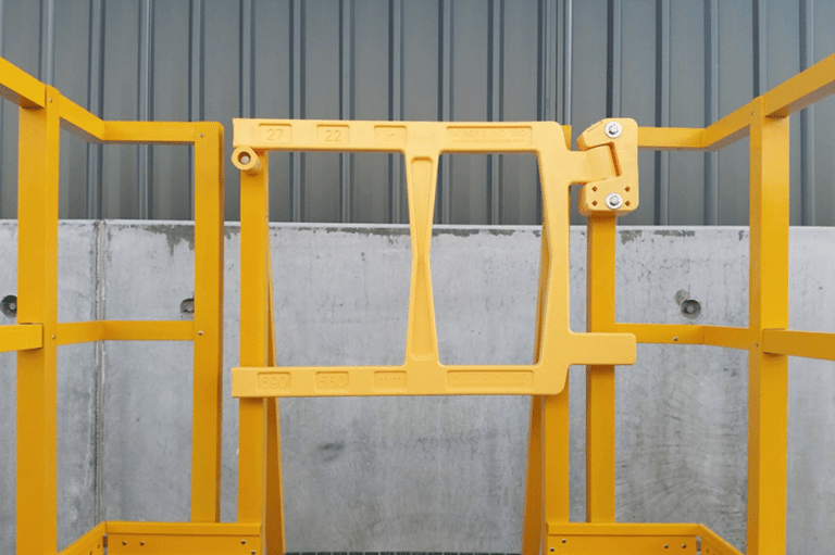 A yellow gravity self-closing safety gate with a door, designed for secure access and safety in various environments.
