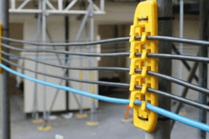 Close-up of a yellow cable track attached to a pole, used for industrial safety procedures.
