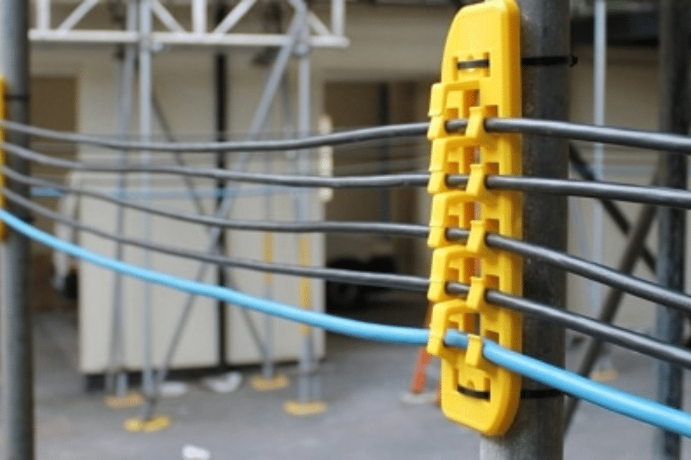 Close-up of a yellow cable track attached to a pole, used for industrial safety procedures.