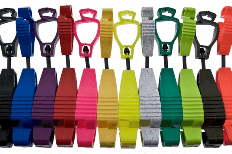 A collection of colorful plastic safety glove clips for workers arranged on a white background.