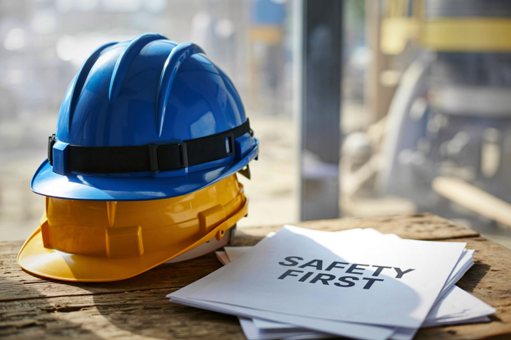 Safety helmet and a safety guidelines paper on a wooden table, emphasizing workplace safety protocols answering the question of "when does osha require a safety gate".